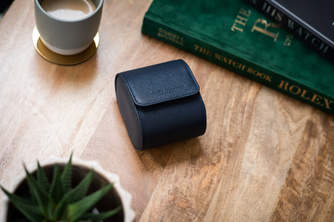  A blue leather watch roll with the words "OLIVER COOPER LONDON" embossed on the front.