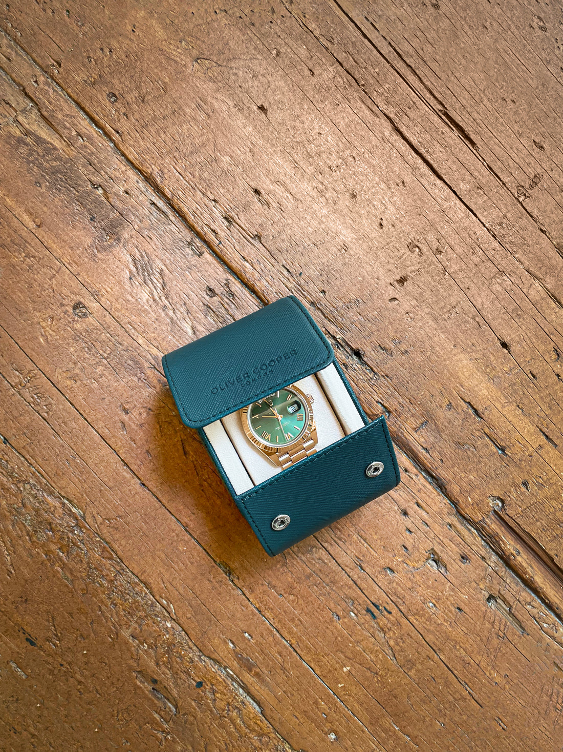  A Rolex watch with a green dial and a gold case, in a green leather case.