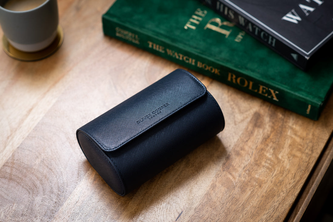  A blue leather watch roll with the words "OLIVER COOPER LONDON" embossed on the front.