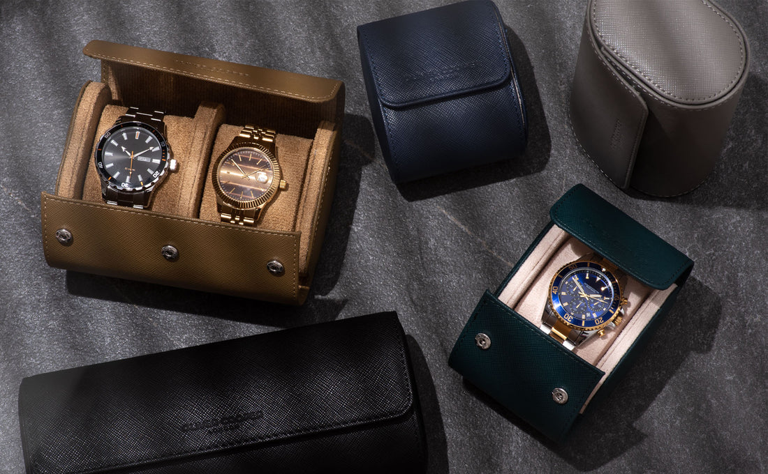 Various luxury watches in different leather watch rolls and cases displayed on a dark surface