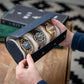 A man holding the blue triple watch case showcasing three watches while also highlighting its design and craftsmanship