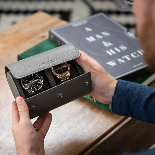 Stylish gentleman showcasing an Oliver Cooper watch roll case and his exquisite watch collection.