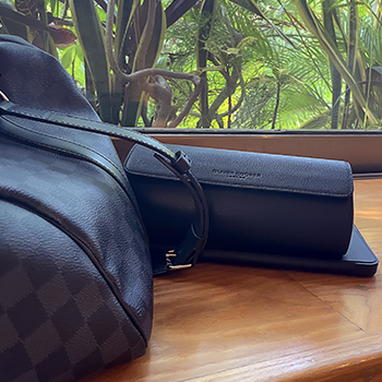 black three watch travel case with a black louis vuitton duffle bag