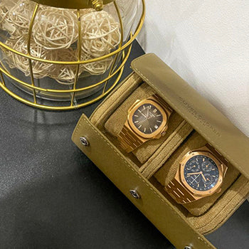 brown watch display case with a rose gold patek philippe nautilus and a rose gold audemars piguet