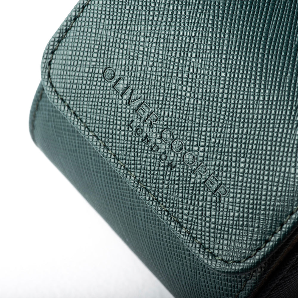 Close-up picture showcasing the teal leather watch travel case with the Oliver Cooper London brand stamp.