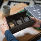 Person holding an open a grey triple watch case with three watches displayed